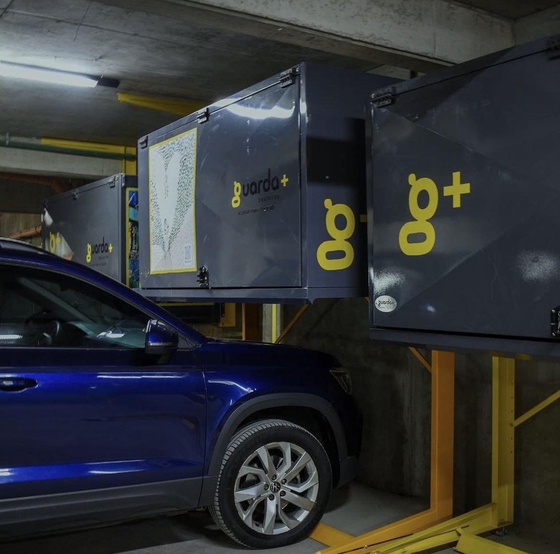 Baulera metálica Guarda+ instalada sobre una camioneta azul en la cochera de un edificio